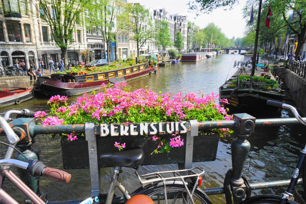 scenic Amsterdam canal with a bike and flowers in the foreground